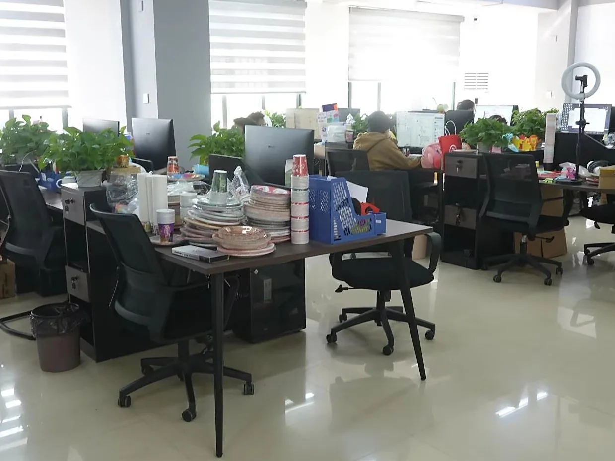 Product development team reviewing sample paper plates, cups and napkins at their desks in the Yiwu office